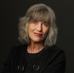 Author Suzanne Nielsen wears a black jacket, with a closed-mouth smile.