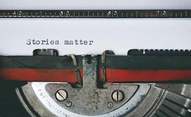 Close-up of a typewriter with the typed words "stories matter" typed on the page.